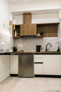 a kitchen with white cabinets and stainless steel appliances at Casa Margarita Parga in Parga +17 photos
