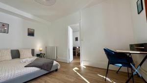 a bedroom with a bed and a desk and a chair at Le bel air in Pougues-les-Eaux