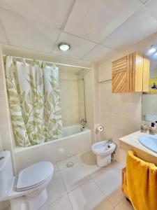 a bathroom with a toilet and a tub and a sink at Preciso atico con jacuzzi en Laguna Beach in Vera