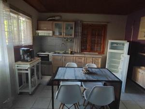 a kitchen with a wooden table and chairs in it at The happy scarecrows in Amalias