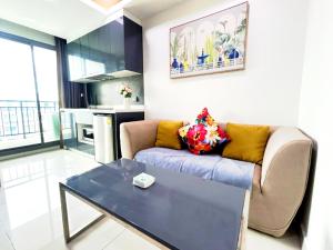 a living room with a couch and a table at Arcadia II Beach hotel in Pattaya South