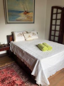 a bed with two pillows on it in a room at Pousada Sunset Itaúna in Saquarema