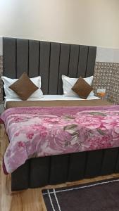 a bed with a purple blanket and pillows at Govind Anand Dham in Vrindāvan