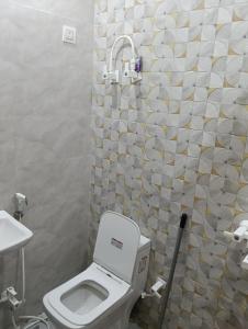 a bathroom with a toilet and a shower curtain at Govind Anand Dham in Vrindāvan