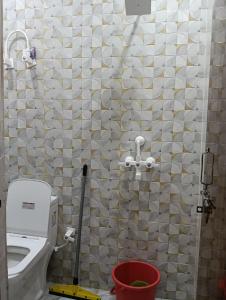 a bathroom with a toilet and a shower curtain at Govind Anand Dham in Vrindāvan