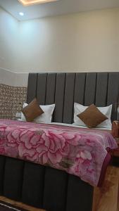 a bedroom with a large bed with a pink blanket at Govind Anand Dham in Vrindāvan