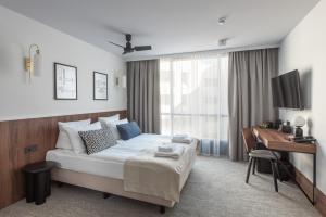 a bedroom with a bed and a desk and a computer at AIRINN Vilnius Airport Hotel RENOVATED 2025 in Vilnius