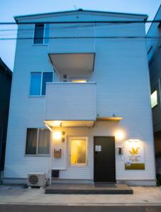 东京お宿寧々東京平和島OyadoNene駅4分的前面有一扇门的白色建筑