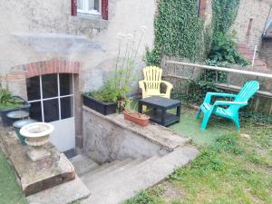 a garden with two chairs and a table and a chair at Studio calme avec billard in Saint-Priest