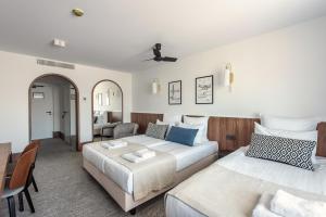 a hotel room with two beds and a table at AIRINN Vilnius Airport Hotel RENOVATED 2025 in Vilnius