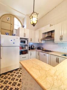 a kitchen with white cabinets and a white refrigerator at Ipekyol Villa avec Piscine Privée in Çeşme
