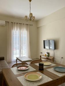 a living room with a wooden table with plates on it at Anefos apartment in Ágios Rókkos