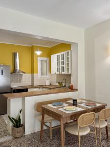 a kitchen with a table and two chairs and a counter at Anefos apartment in Ágios Rókkos