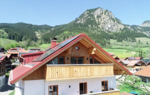 a house with a red roof with mountains in the background at Ferienwohnungen Göhl in Bad Hindelang