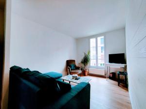 a living room with a couch and a table at Ardillière - Séjour à Auxerre in Auxerre