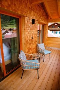 two chairs and a table on a wooden deck at Ferienwohnungen Göhl in Bad Hindelang +23 photos