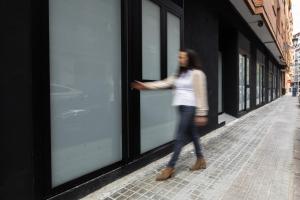 a woman walking down a street looking into a store window at Apartamento Río Turia 4 in Valencia