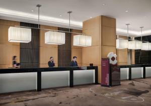 a lobby with two men standing at a reception desk at The Azure Ningbo, Vignette Collection by IHG in Ningbo +117 photos