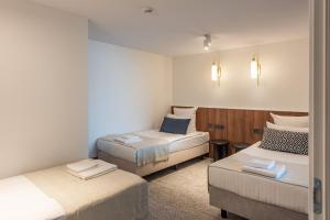 a room with two beds and a chair in it at AIRINN Vilnius Airport Hotel RENOVATED 2025 in Vilnius