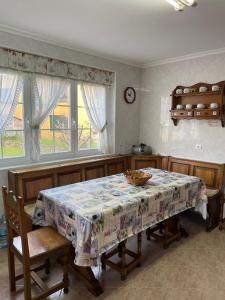 ein Esszimmer mit einem Tisch und zwei Fenstern in der Unterkunft Villa Pepita in Ayuela