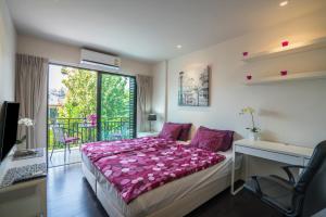 ein Schlafzimmer mit Bett, Schreibtisch und Fenster in der Unterkunft Apartments in The Title Beach Rawai in Rawai Beach + 43 Fotos