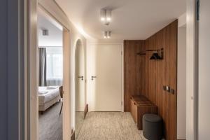 a bedroom with a bed and a door leading into a room at AIRINN Vilnius Airport Hotel RENOVATED 2025 in Vilnius