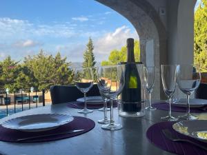 a table with wine glasses and a bottle of wine at Villa Copacabana Family Loft in Jávea