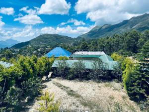 an aerial view of a house with mountains in the background at Aden Valley in Kanthalloor