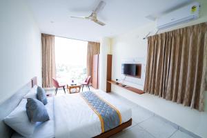 a bedroom with a bed and a tv and a window at Sri Sai Castle IN in Bangalore