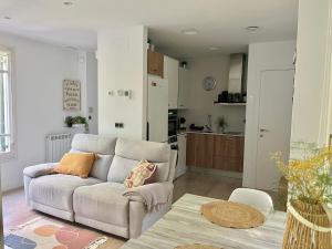 een woonkamer met een bank en een keuken bij La Casa de la Brujita with AC License ESS02999 in San Sebastian