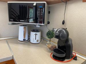 a kitchen counter with a coffee maker and a microwave at Villa Stella - private house with parking spot, pool and sea view in Varna City