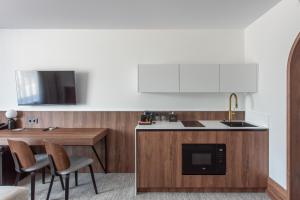a kitchen with a sink and a table with chairs at AIRINN Vilnius Airport Hotel RENOVATED 2025 in Vilnius