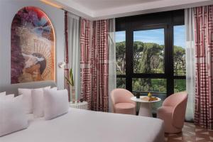 a bedroom with a white bed and a large window at nhow Roma Vittorio Veneto in Rome