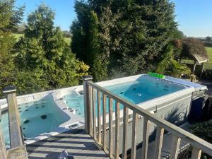 ein Whirlpool auf einer Terrasse mit Berater in der Unterkunft Caesars Spa Retreat with Heated Swim Spa & Waterfall Gardens in Darlington