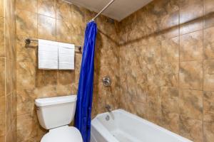 a bathroom with a toilet and a tub at Admiral Motel By OYO Chicago I-94 in Chicago +17 photos
