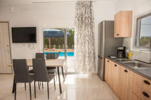 a kitchen and dining room with a table and chairs at Summer Villa Thea in Karavadhos
