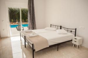 a bedroom with a bed and a pool at Summer Villa Thea in Karavadhos +14 photos