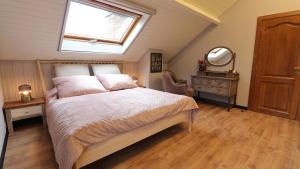 a bedroom with a bed with a window and a mirror at Gite de l'oseraie  +24 photos