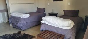 twee bedden en een bank in een kamer bij Cookhouse Cottages in Vosburg