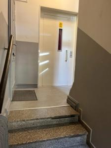 a hallway with a door and stairs in a building at Lägenhet med 6 sovplatser i centrala Göteborg! in Gothenburg