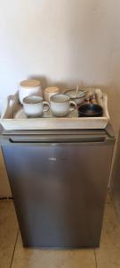 een groep kommen en schalen bovenop een koelkast bij Cookhouse Cottages in Vosburg