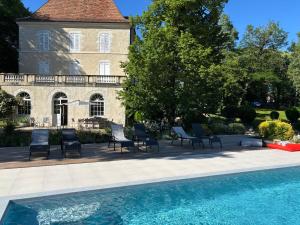 a house with a swimming pool in front of a building at Château de Foussal in Issigeac
