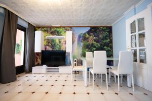 a dining room with a large painting on the wall at Apartalux Aqua Sol in Grao de Castellón +42 photos