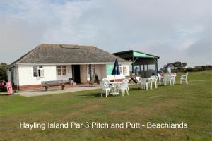 a building with chairs and a table in the yard at Seafront Studio Snug by the Sea - Sea Views in South Hayling