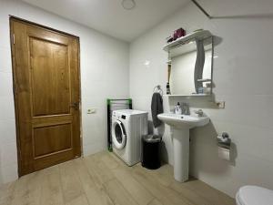 a bathroom with a sink and a washing machine at GT moto base in Shavsopeli