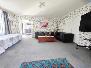 a bedroom with a bed and a couch and a table at big sale was 258 now from 138 for 2or3 bedrooms in Wellington
