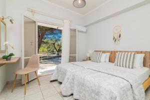 a white bedroom with a large bed and a window at Villa La Onta by Villa Plus in Makris Gialos +16 photos