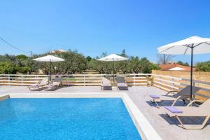 a swimming pool with lounge chairs and umbrellas next to a pool at Villa La Onta by Villa Plus in Makris Gialos