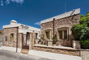 a stone building with a gate in front of it at Akrolithos Apartments in Ierapetra