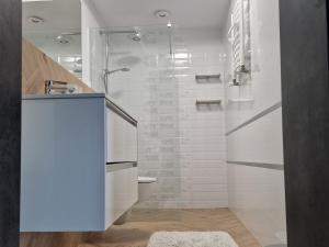 a white bathroom with a shower and a toilet at Pluma in Grzybowo